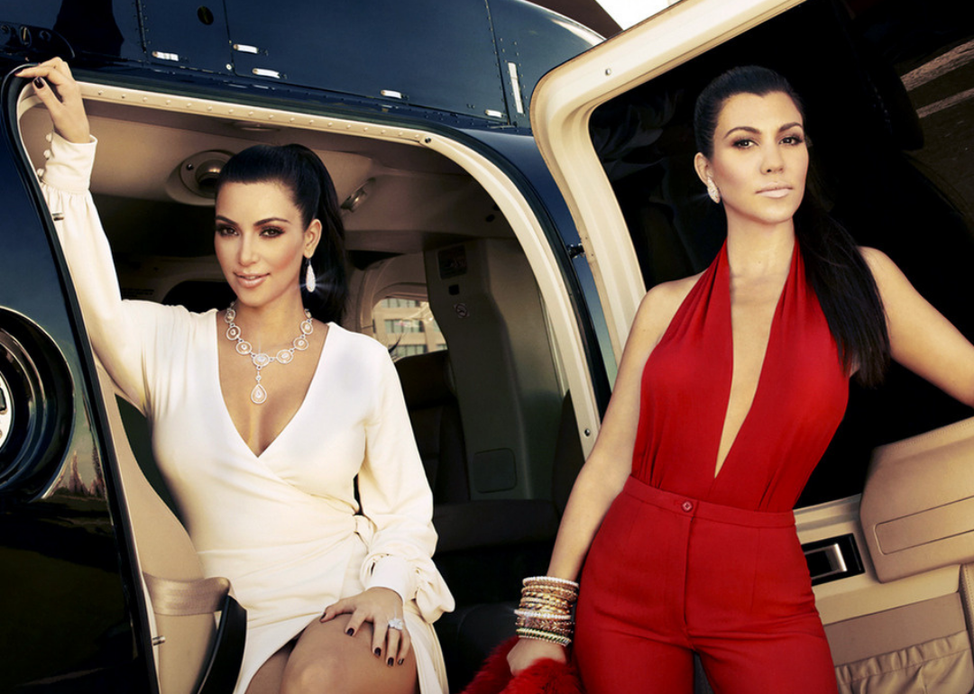 Kourtney and Kim Kardashian in front of a helicopter.