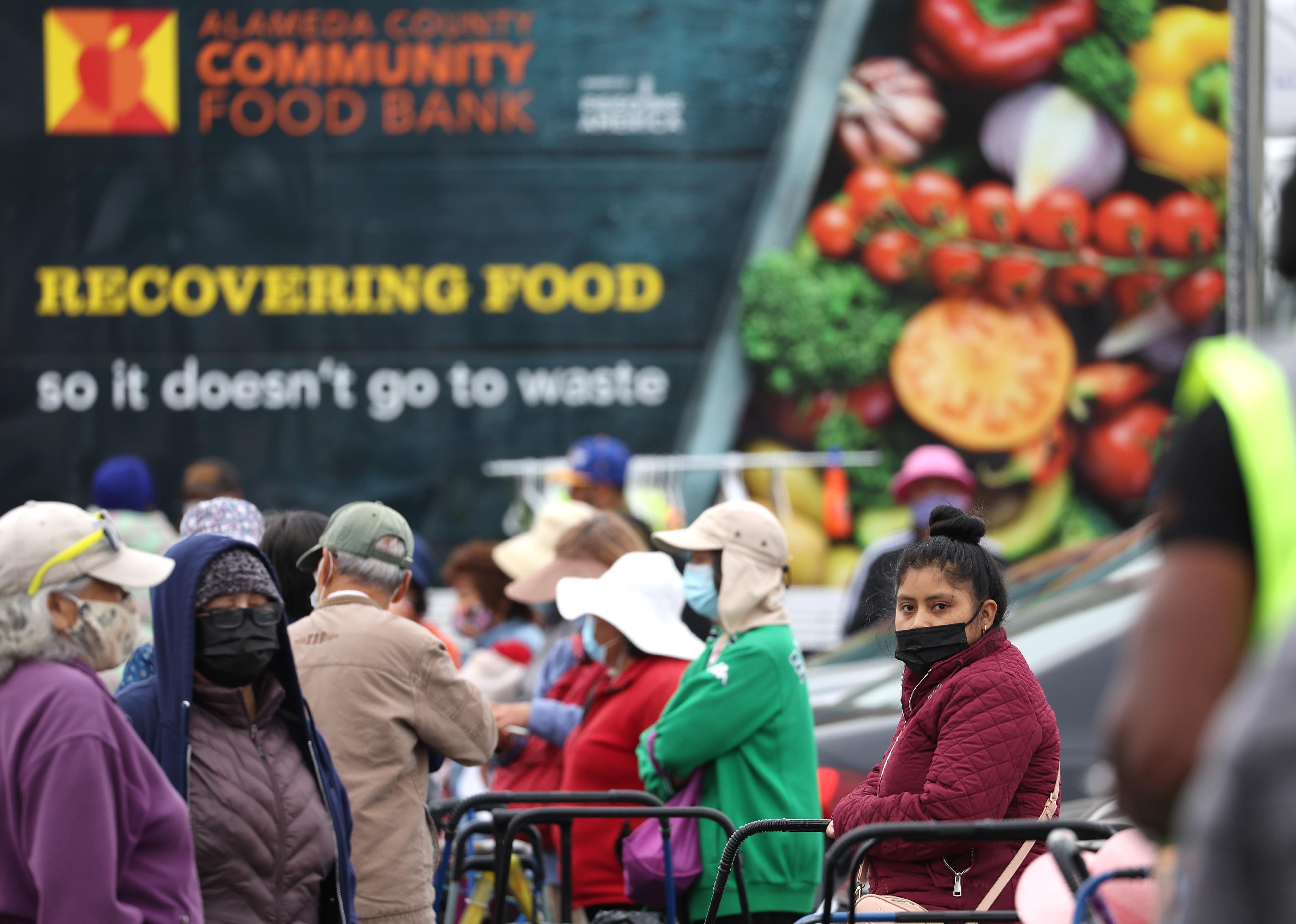 People waiting for packages of food at a food bank.