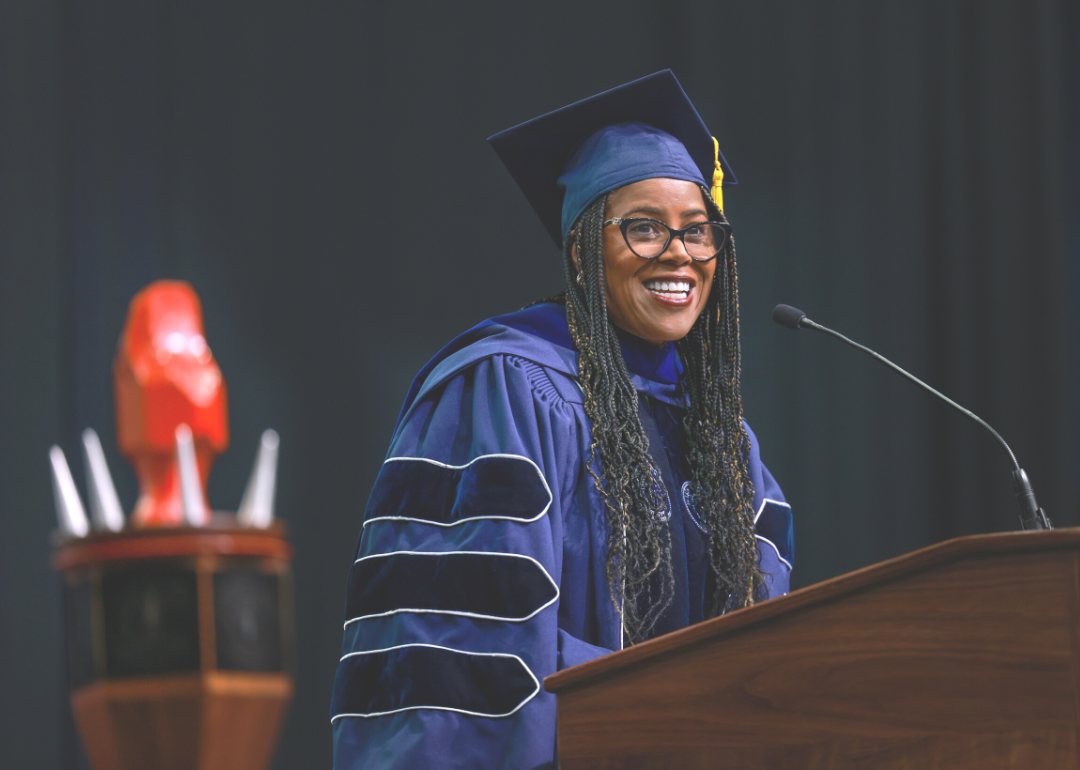 Thasunda Duckett delivering a college commencement speech in a cap and gown.