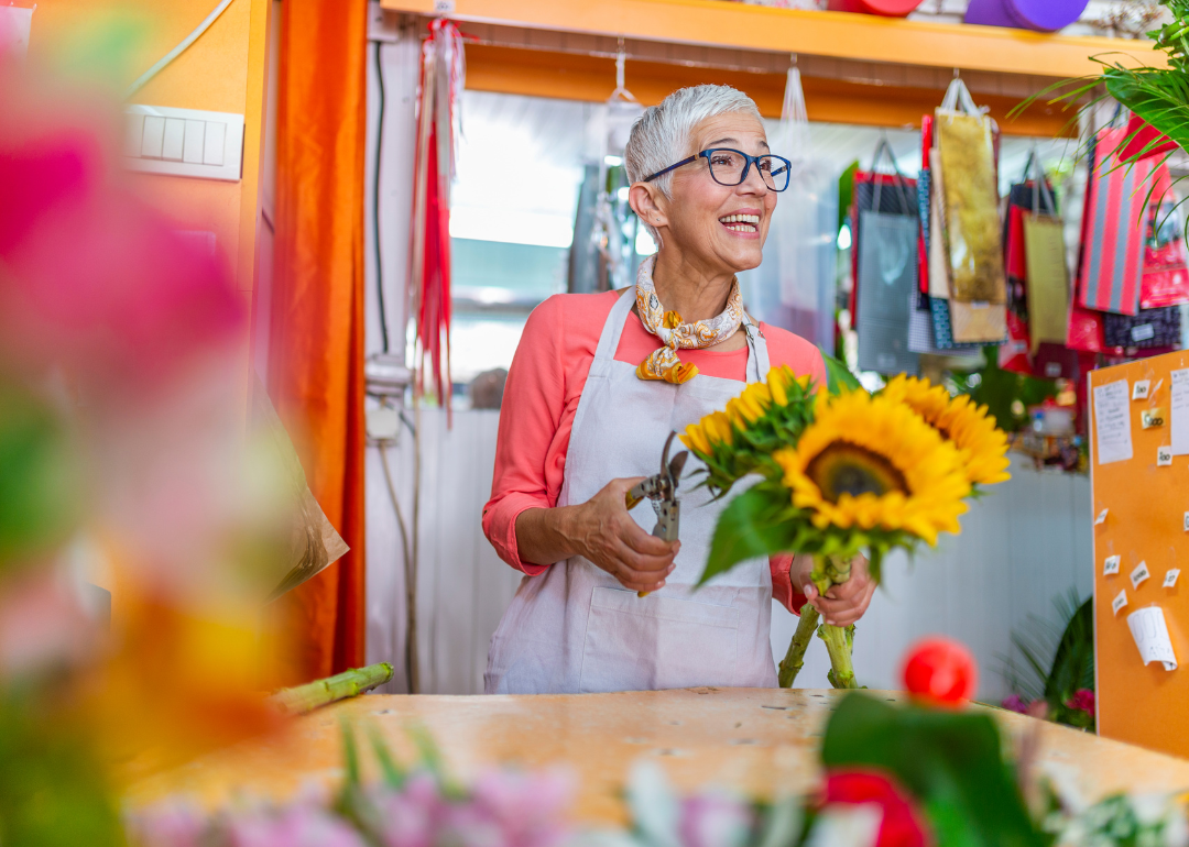 A flower shop owner trimming sunflowers.