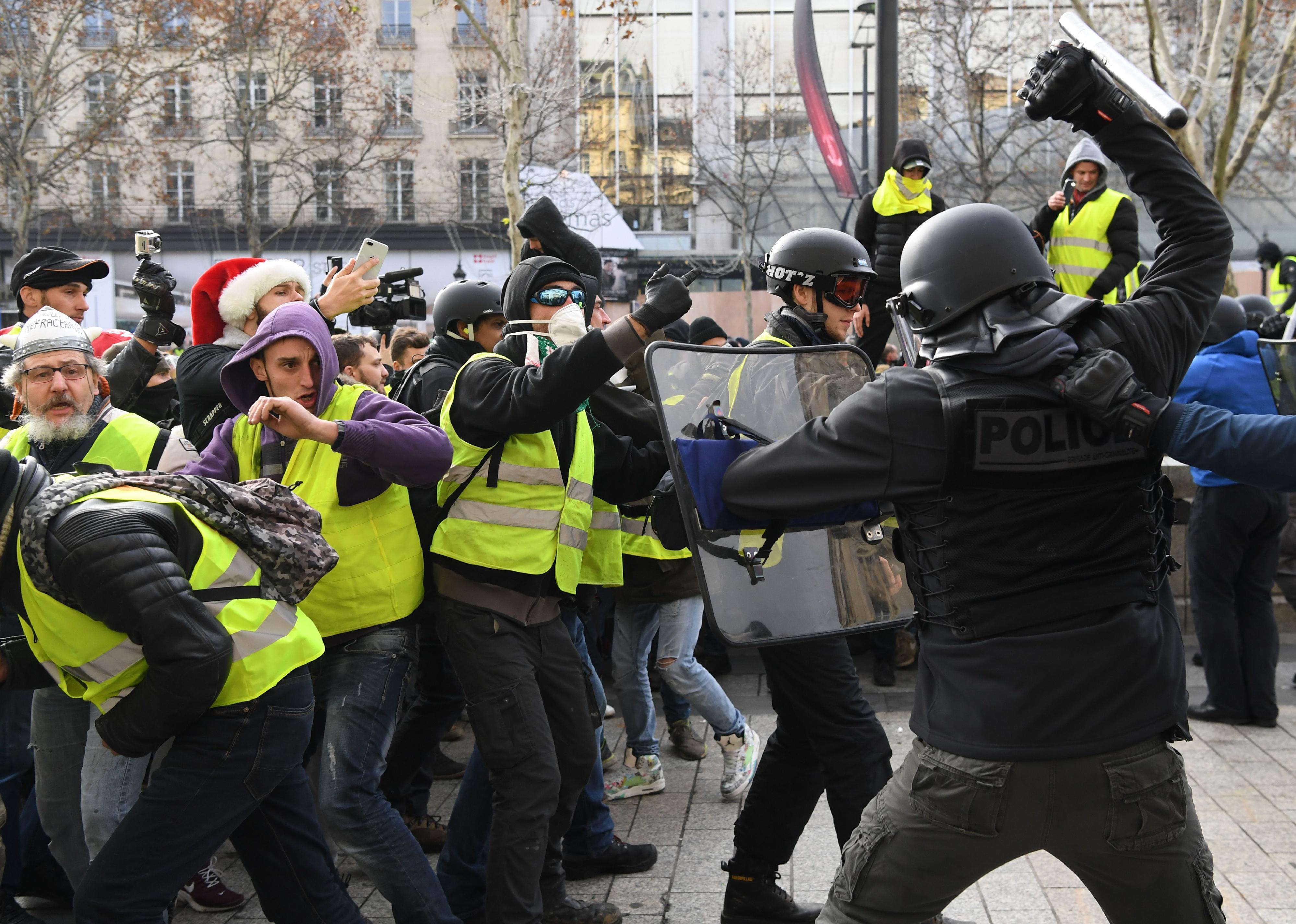 Riot police clash with men wearing yellow vests