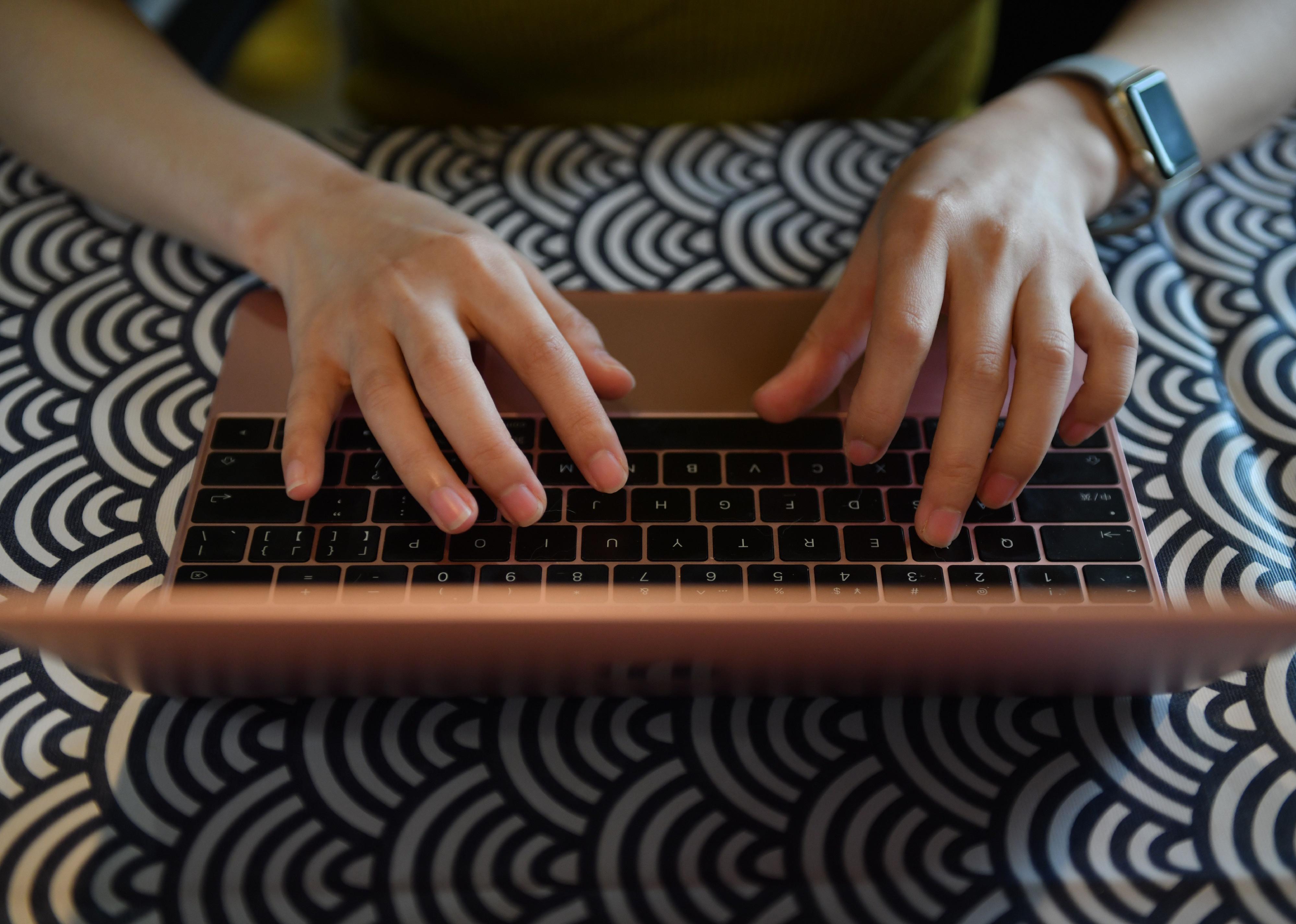 Close up top view of two hands on laptop keyboard