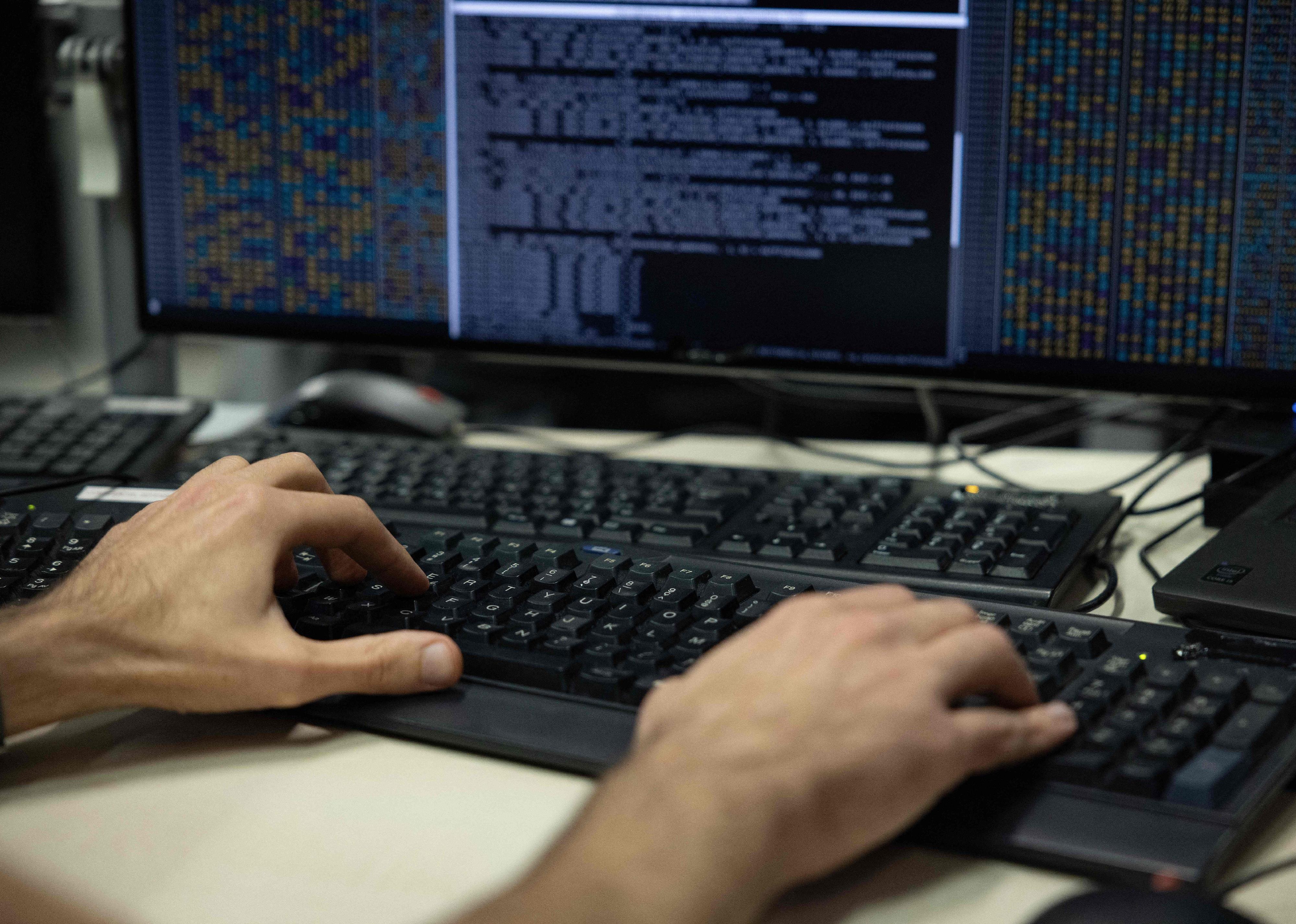 An agent of the operational center of the ANSSI checks datas on a computer.