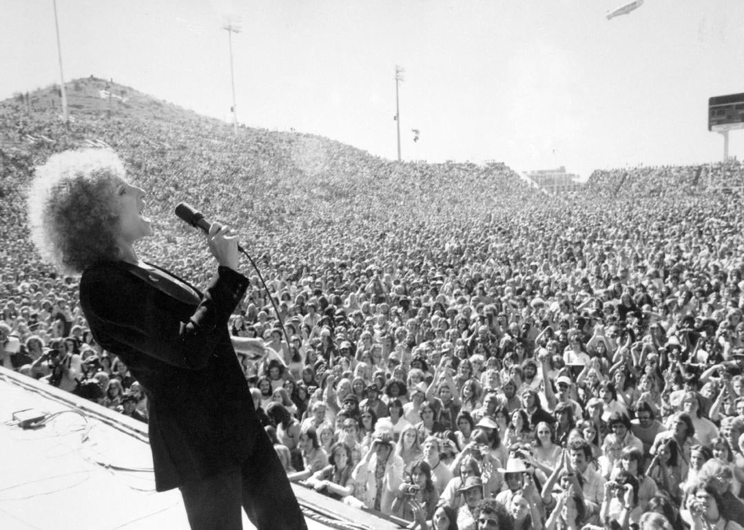 Barbra Streisand performing to a crowd at Phoenix Tempe Football Stadium.