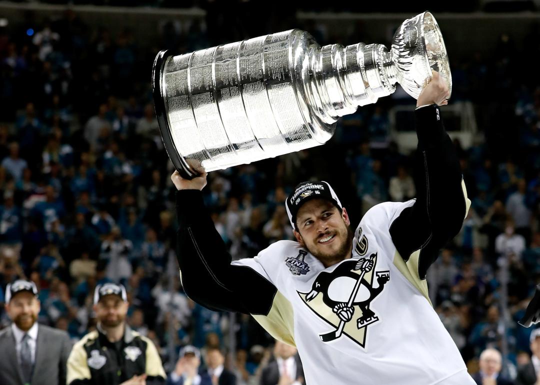 Sidney Crosby celebrates by hoisting the Stanley Cup after a victory