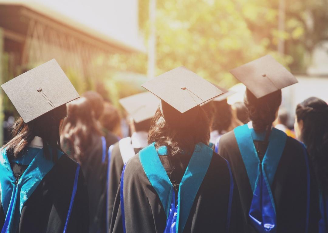 A group of graduates in caps and gowns from the back.