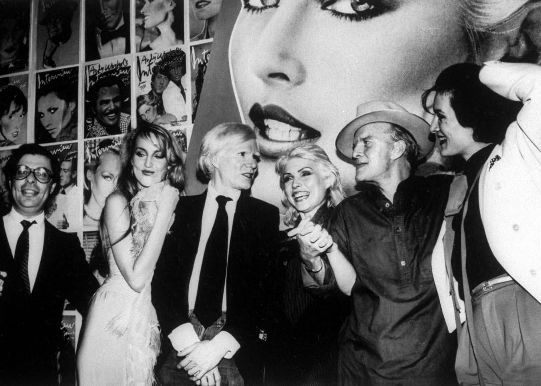 Bob Colacello, Jerry Hall, Andy Warhol, Debbie Harry, Truman Capote and Paloma Picasso at a party.