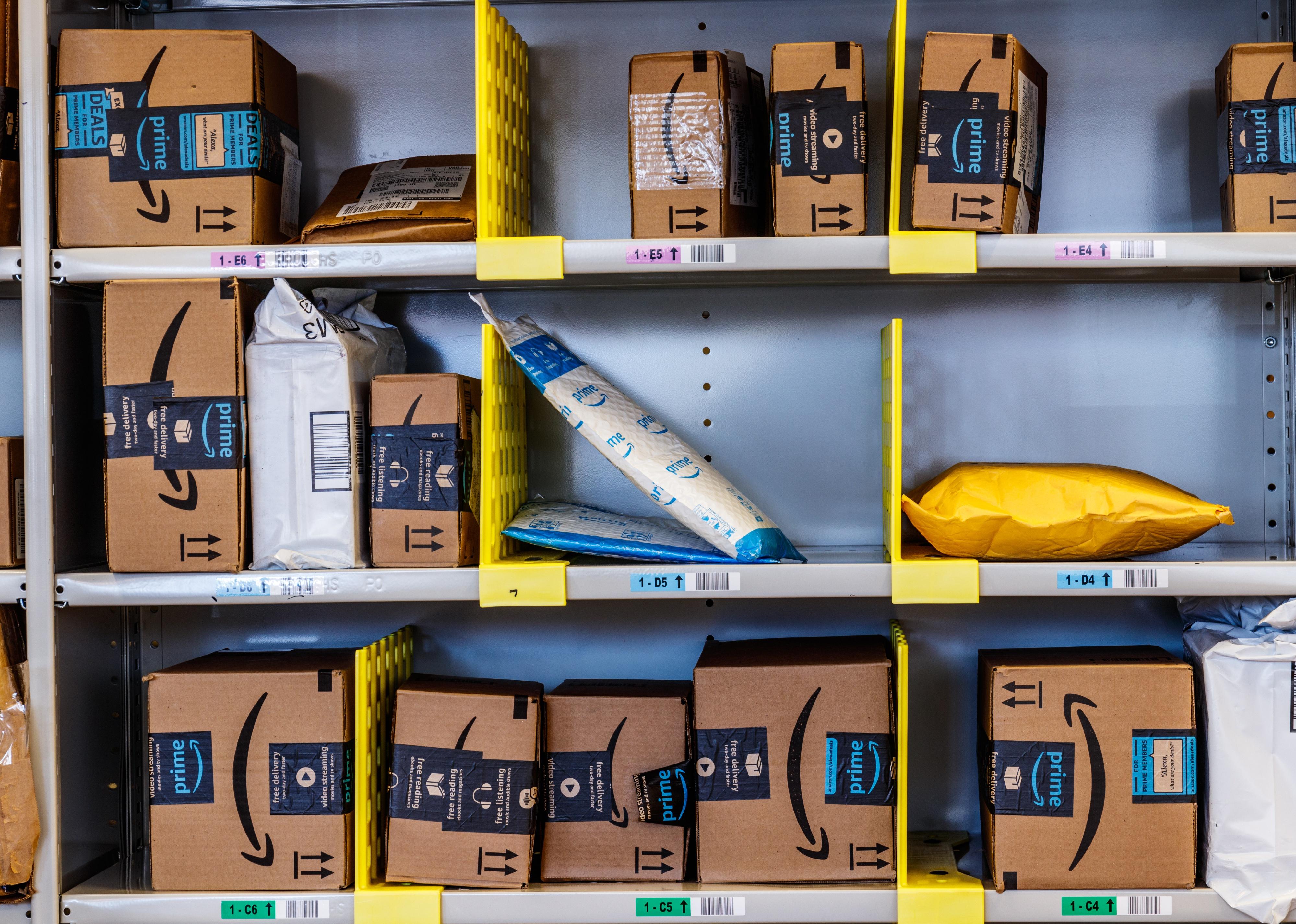 Three rows of shelves filled with Amazon packages