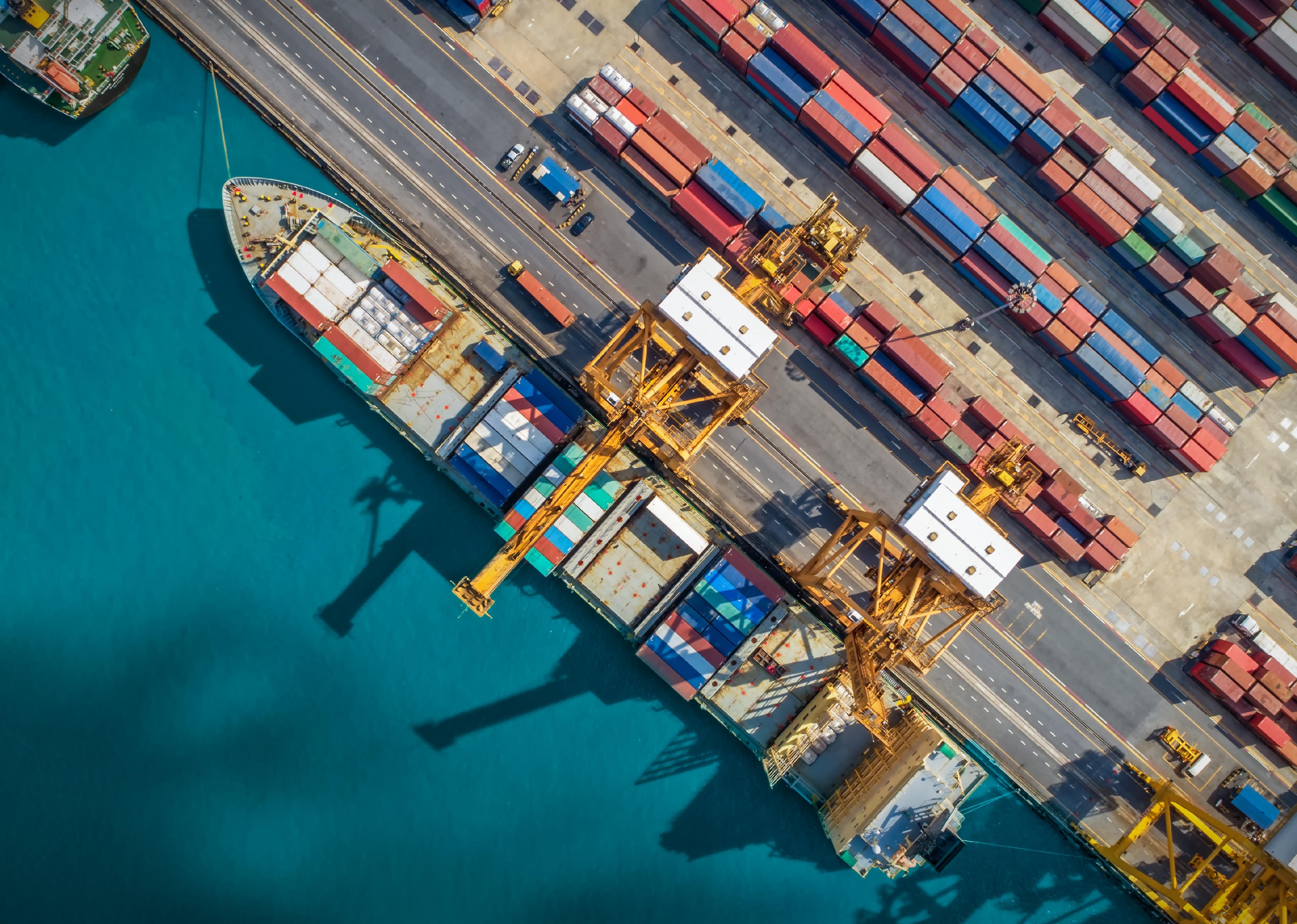 Container Cargo ship and Cargo plane with working crane bridge in shipyard.