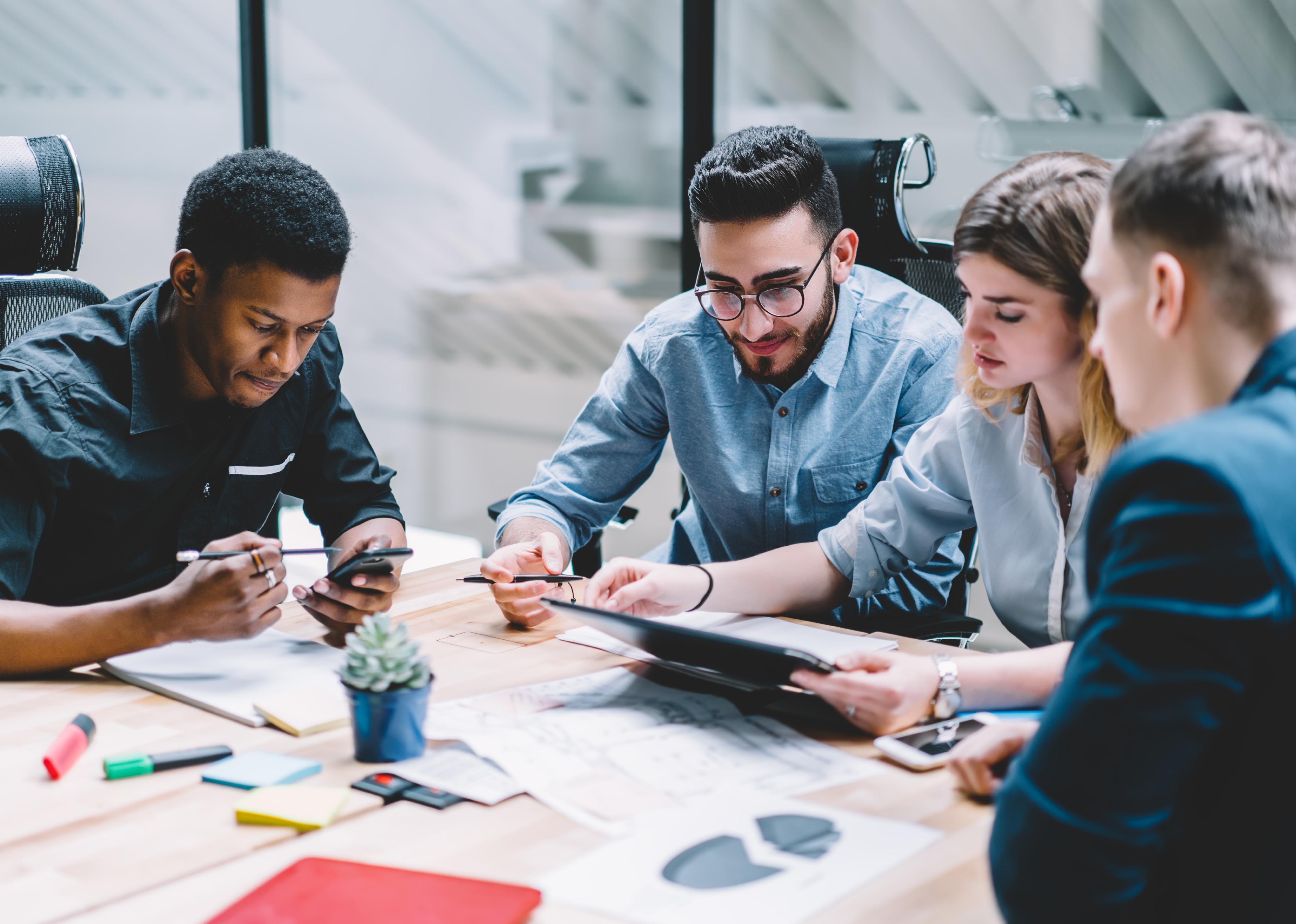 Four colleagues working together in a meeting.