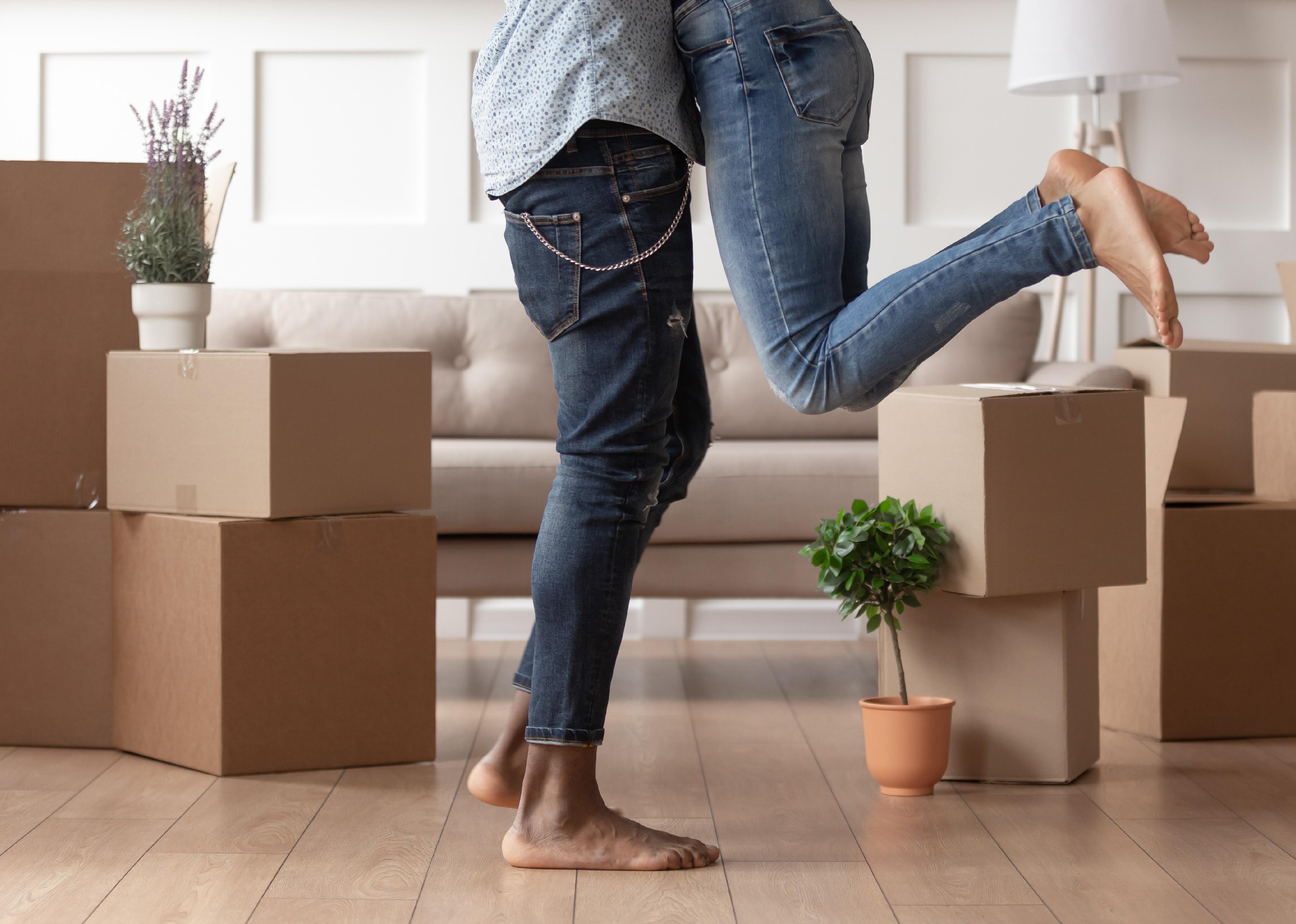 Close up of a man lifting a woman surrounded by boxes