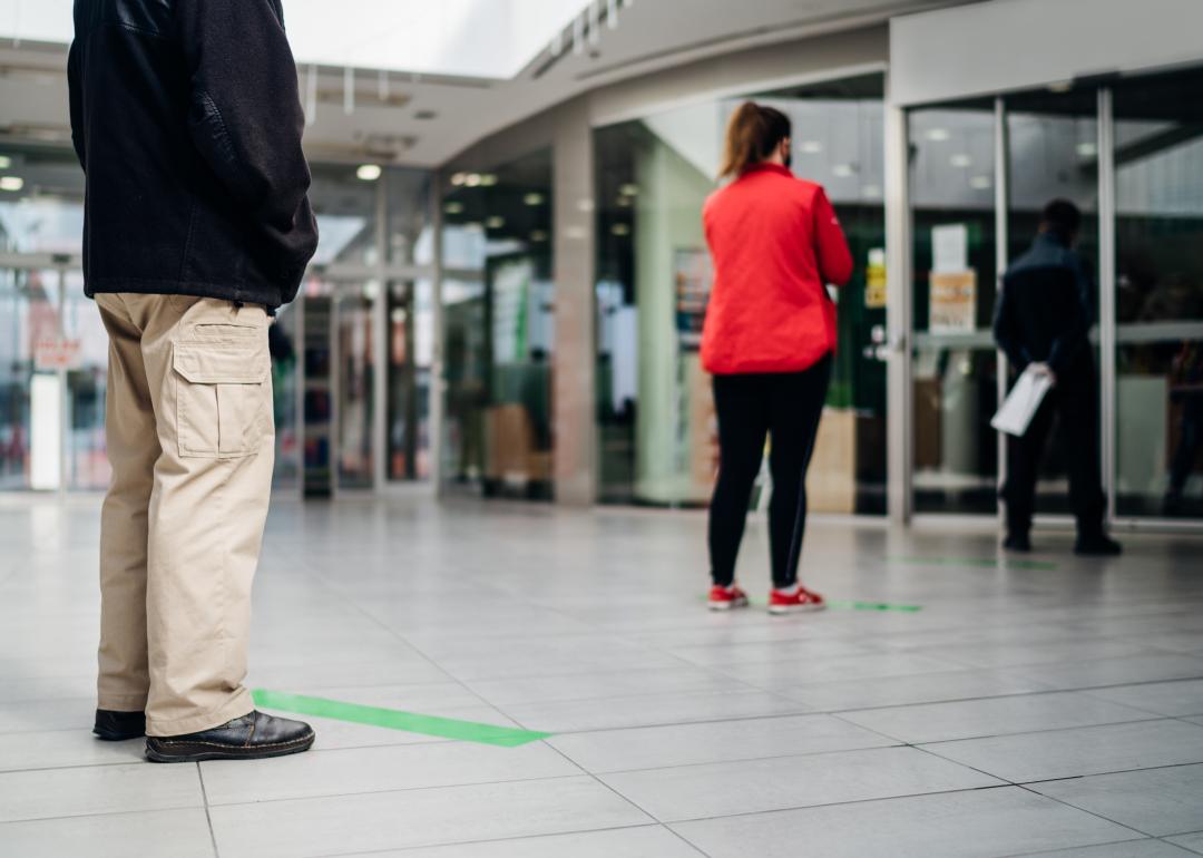 People standing in line in front of a store with distance between them per pandemic-related safety measures.