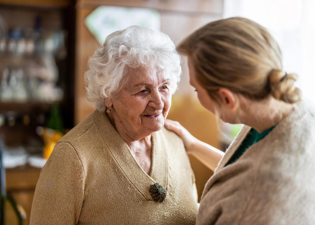 Health care worker talking to an older woman during a home visit.