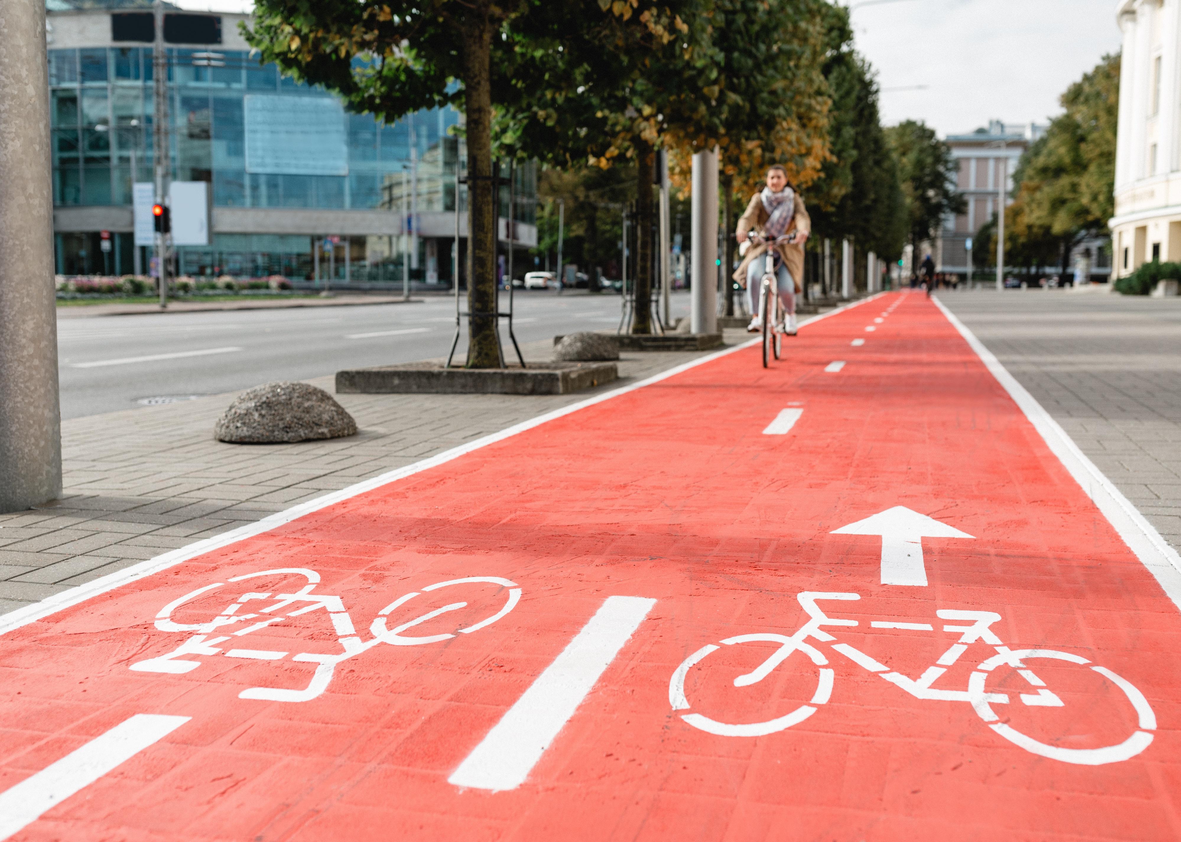 Woman cycling along red bike lane