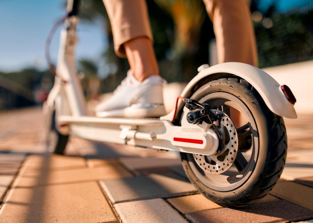 Close-up image of a person's feet on an electric scooter.