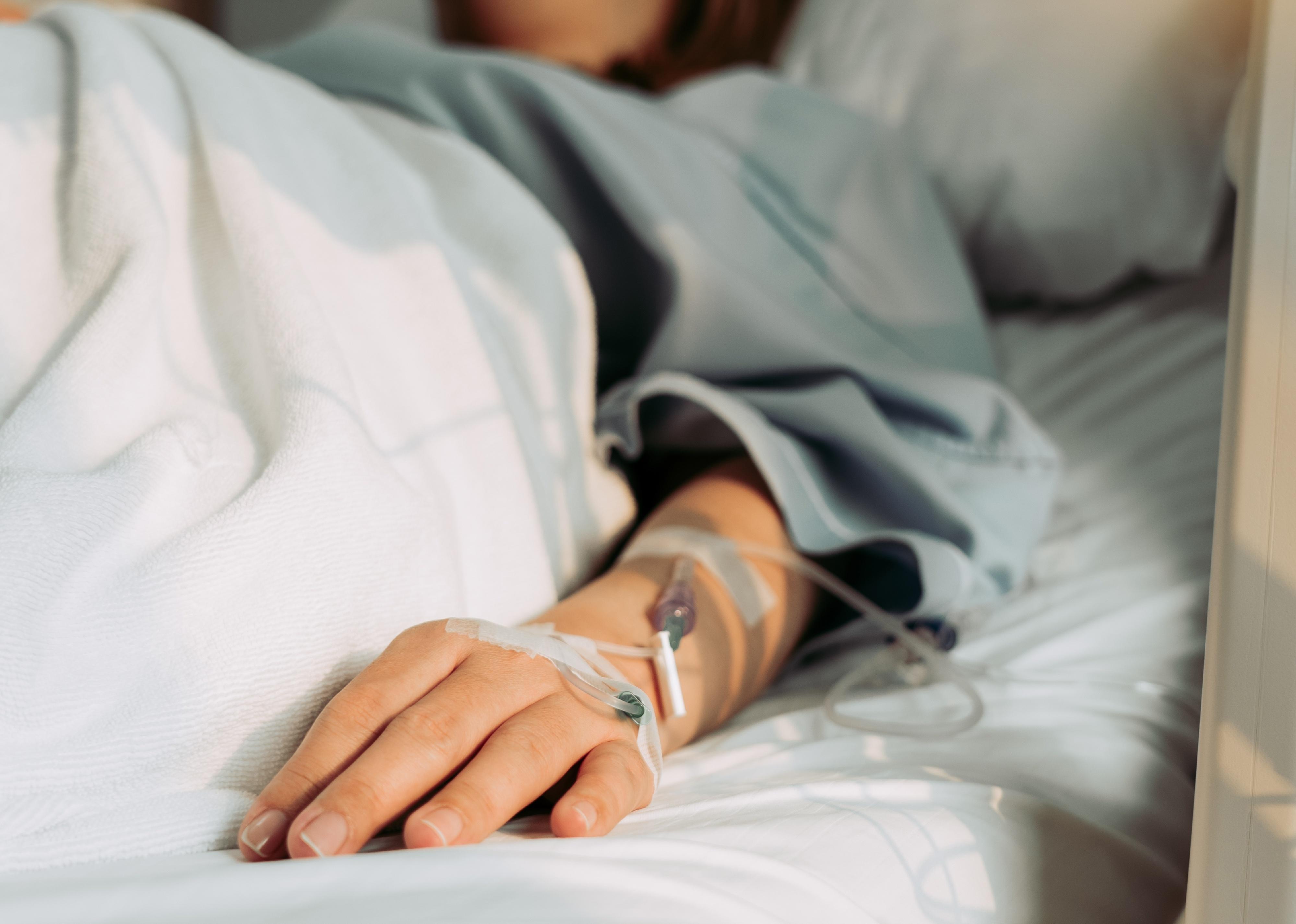 Woman lying in hospital bed.