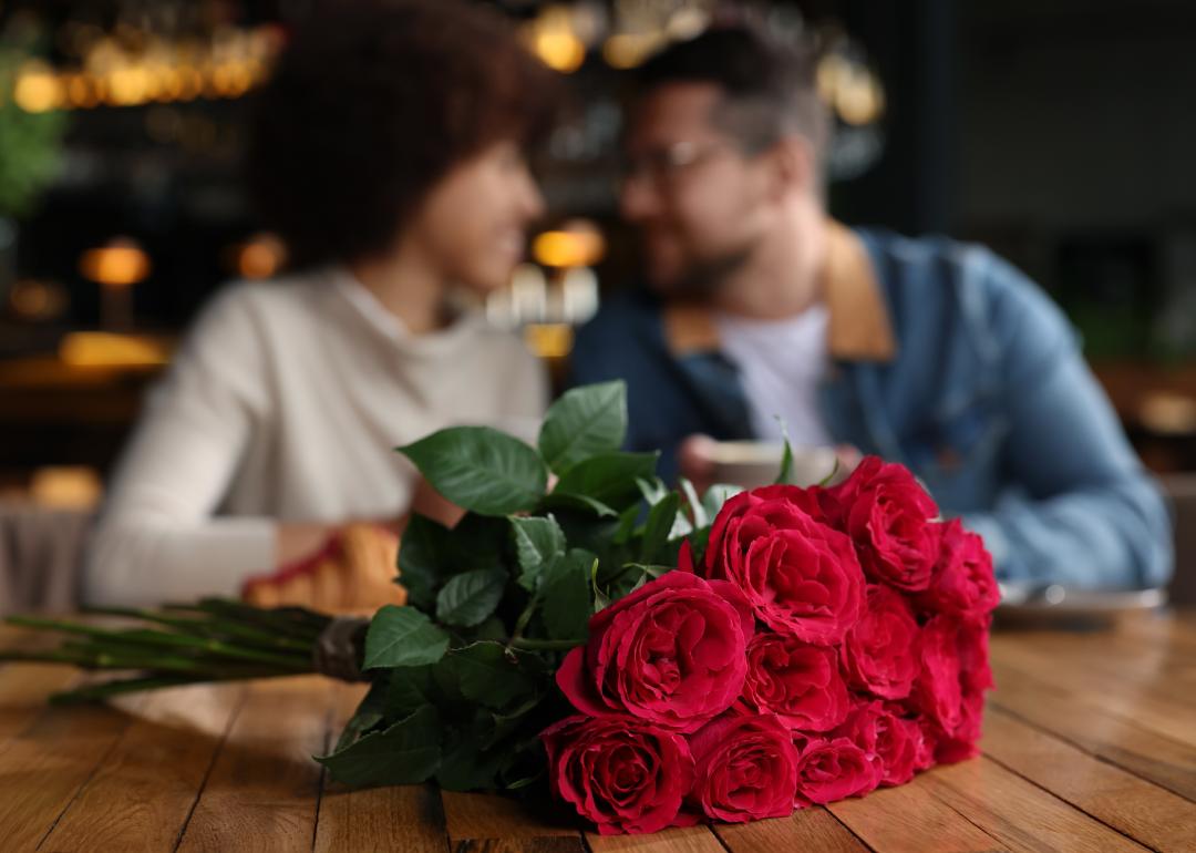 Focus on roses in front of a happy couple.