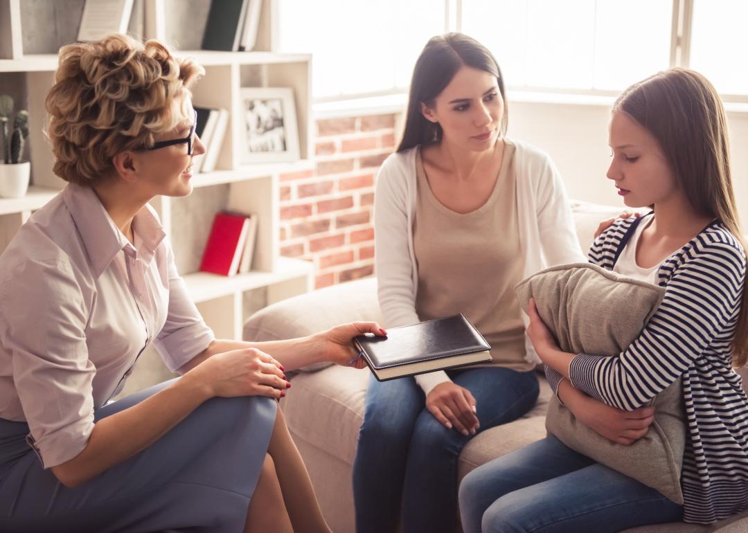 Mom and teenage daughter speaking with a counselor.