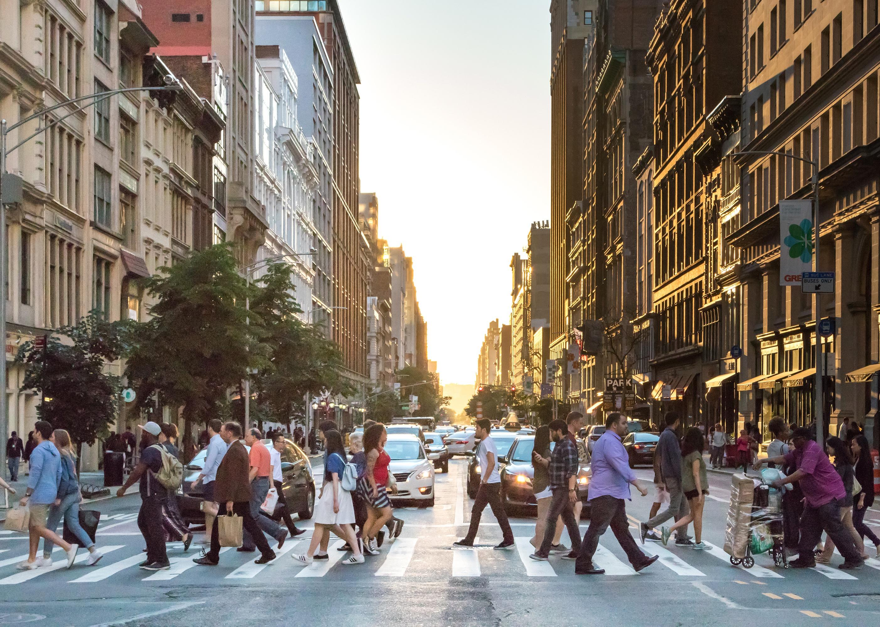 Busy crowds of people cross an intersection in Manhattan, New York City