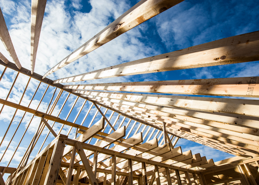 A new home being framed with a blue sky overhead.