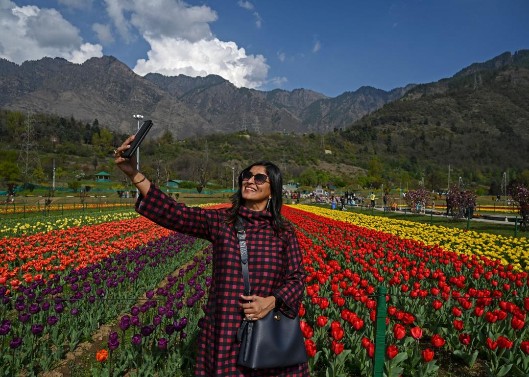 A woman taking a selfie in a field of flowers.