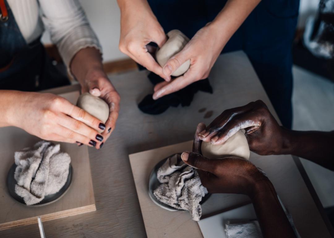 Hands working on pottery.