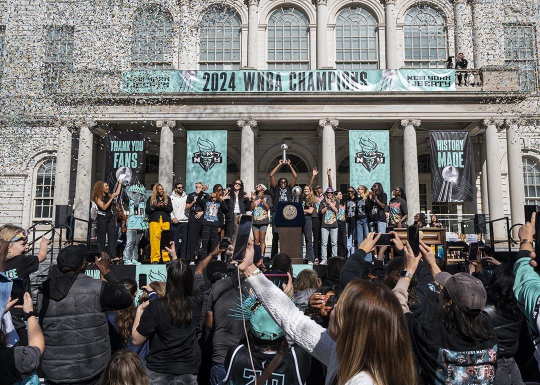 Members of the New York Liberty team celebrate their championship at a ticker tape parade.