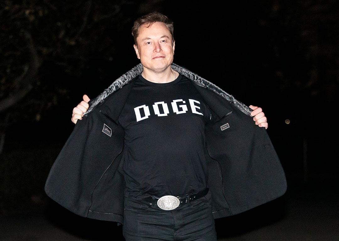 Elon Musk reveals a DOGE t-shirt and a Tesla belt buckle before entering the White House on March 9, 2025.