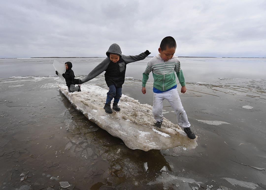  Schoolchildren play on melting ice at the climate change affected Yupik village of Napakiak on the Yukon Delta in Alaska on April 18, 2019.