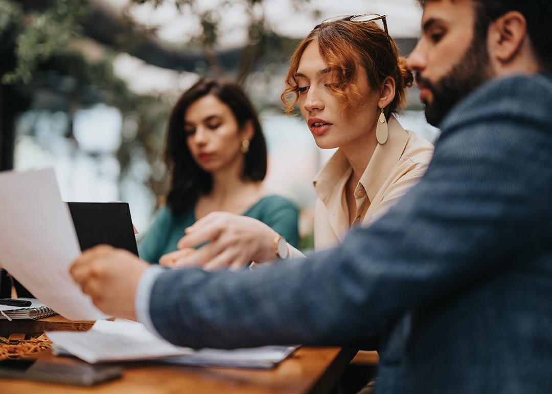 Three startup business colleagues discussing during a casual coffee meeting.