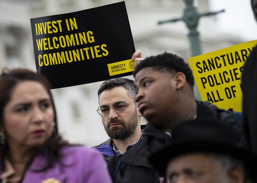 People hold signs in support of sanctuary city mayors outside the U.S. capitol, on Wednesday, March 5, 2025 in Washington, D.C.