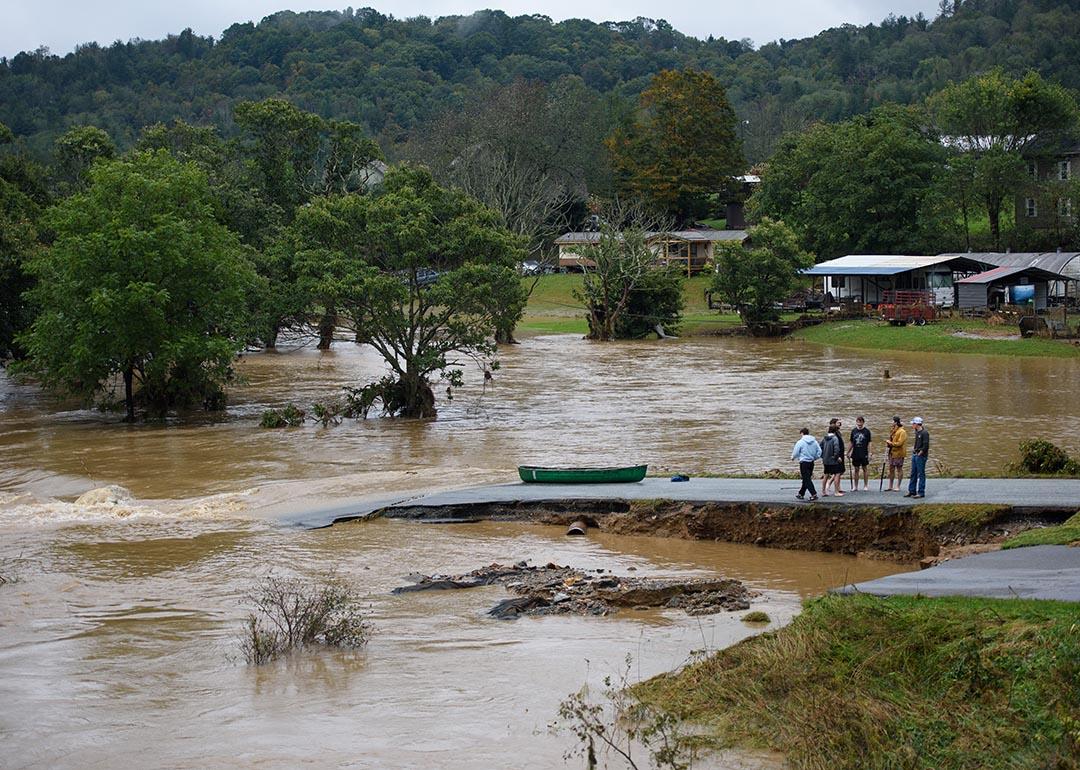 Residents that canoed the flooded South Fork New River talk at a washed out road on September 27, 2024 in Boone, North Carolina