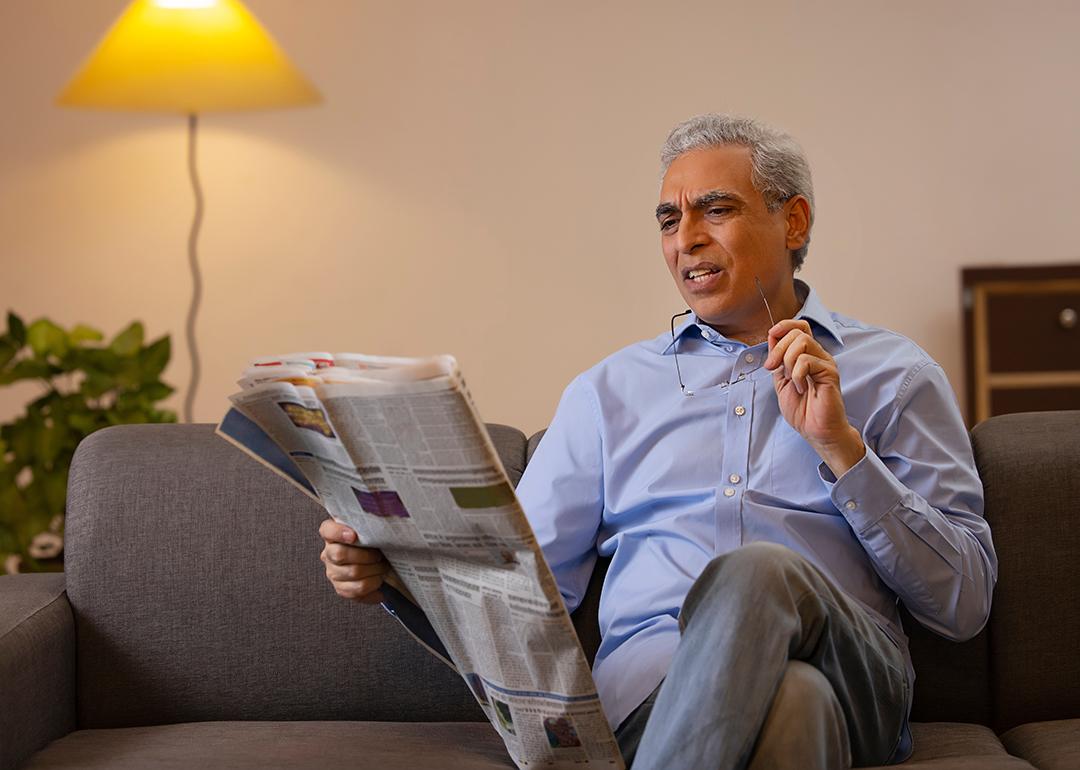 Senior man reading a newspaper in confusion.