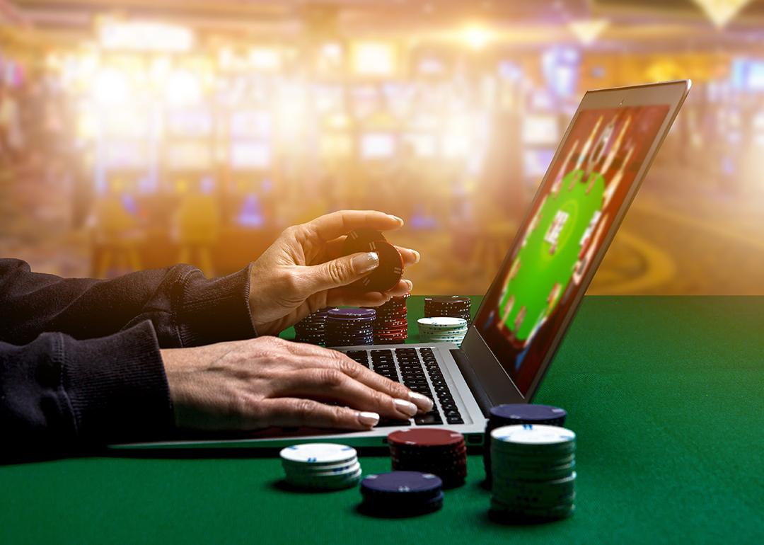 Person using laptop playing online casino.