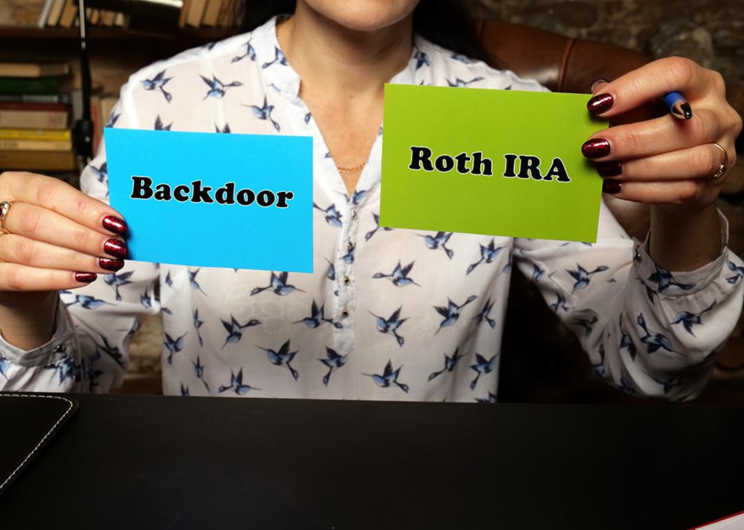 Person holding up two notes with "backdoor" and "Roth IRA" written on each.