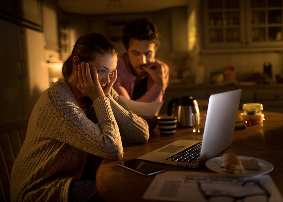 Young couple stressfully looking at their laptop.