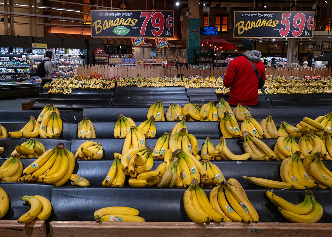 Staff stocking up the organic bananas aisle with a large low prices sign at a grocery store in Brooklyn, New York.