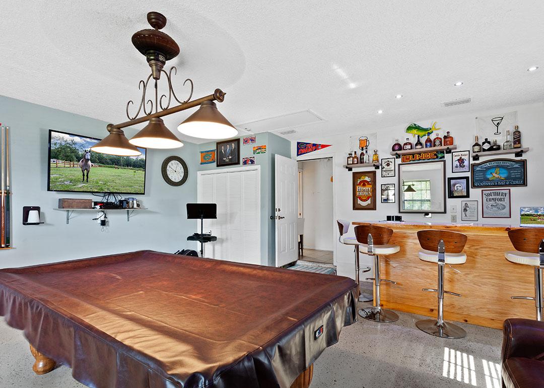 A pool table covered in leather in a game room.