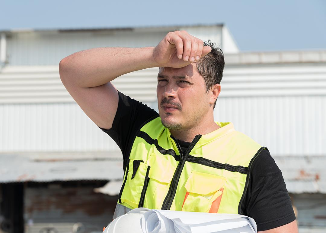 Foreman construction worker wiping sweat while at work.