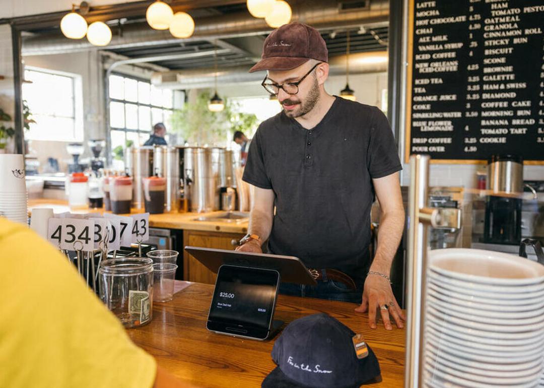 A restaurant staff mans the cashier and inputs order from a customer.