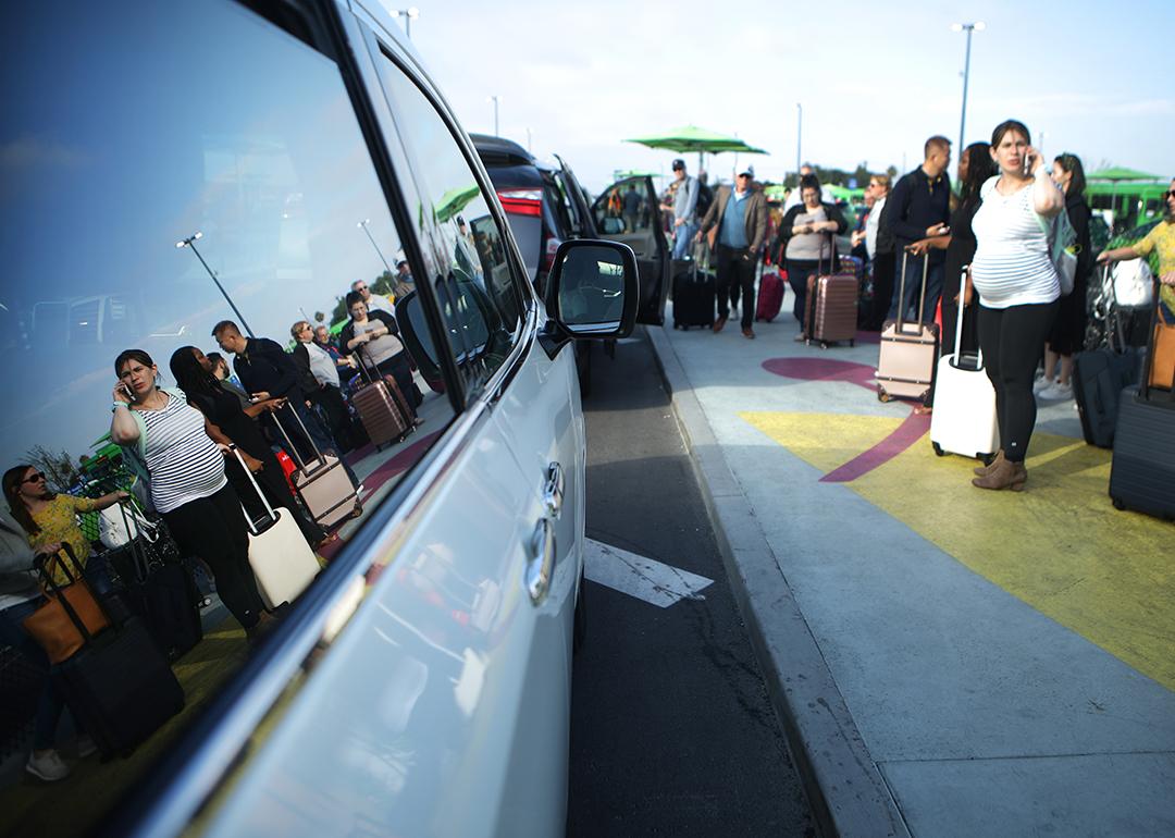 Arriving passengers wait to board Uber vehicles at the new 'LAX-it' ride-hail passenger pickup lot at Los Angeles International Airport (LAX) in California.