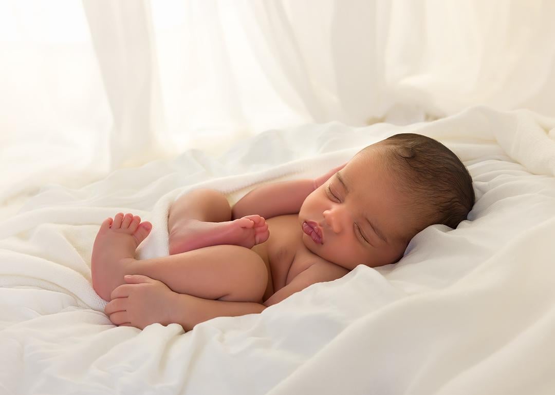 Newborn baby sleeping in bed.
