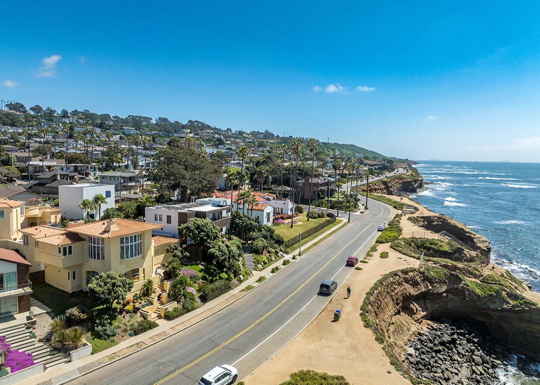 Aerial view of hillside luxury single family homes above Sunset Beach, San Diego with palm trees and terraces.