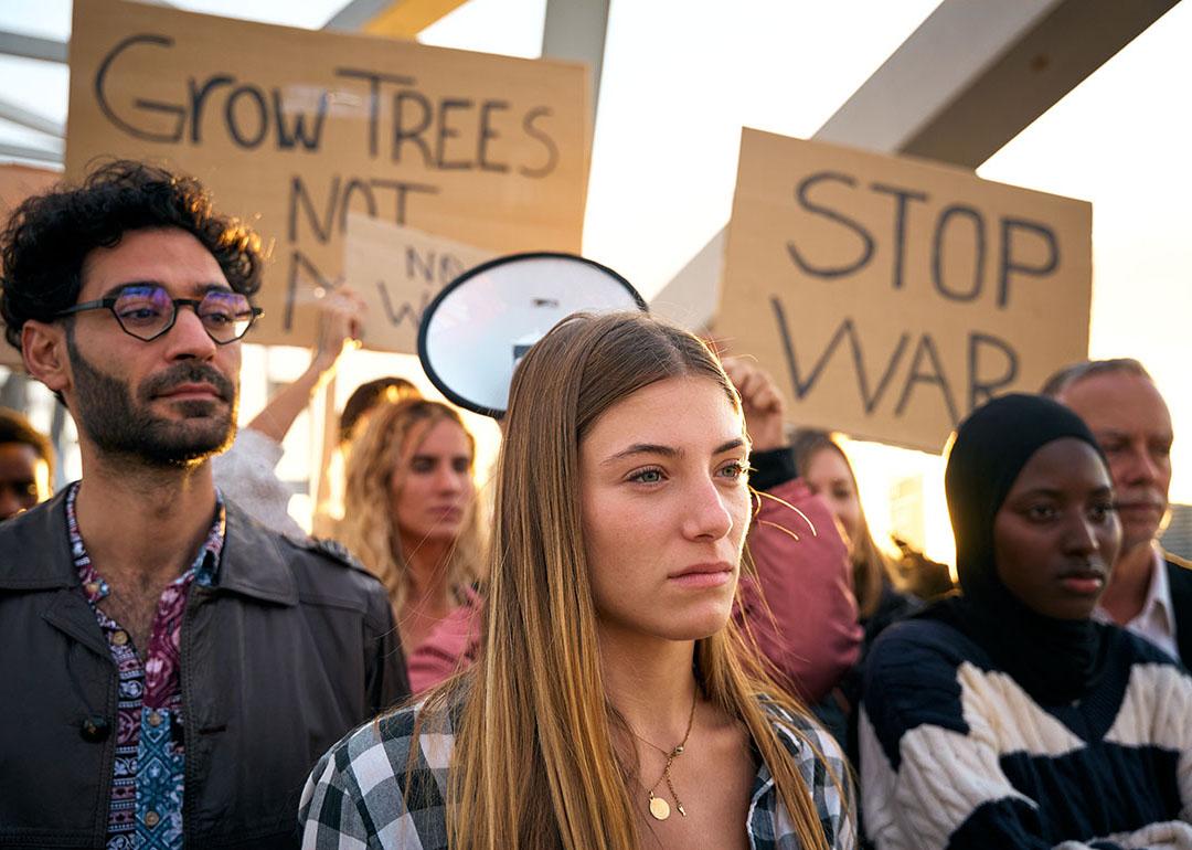 A group of diverse people protesting against war in silence outdoors.