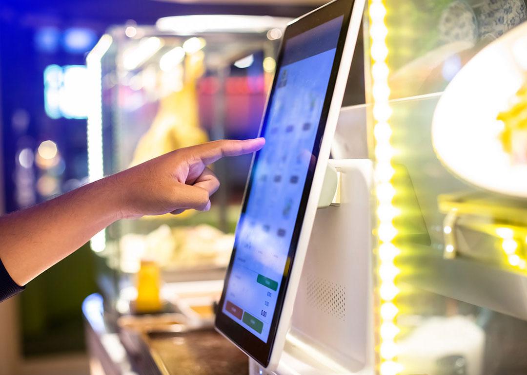 Customer using a digital menu to choose their food and pay electronically.