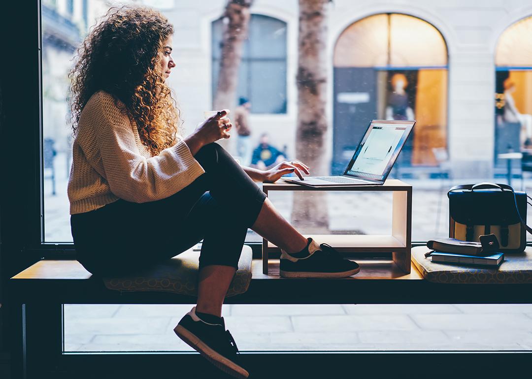 Young woman working by the window of a coworking space.