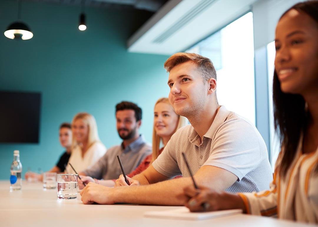A group of post-graduate candidates in a boardroom.