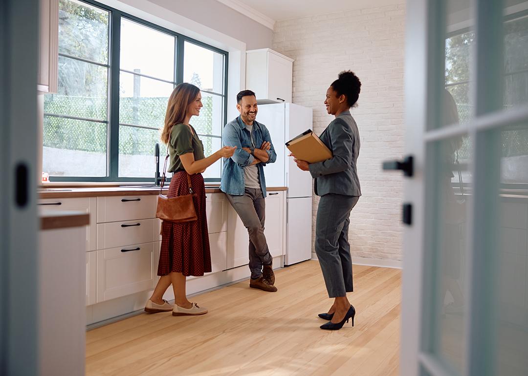 A couple talking with a real estate agent.