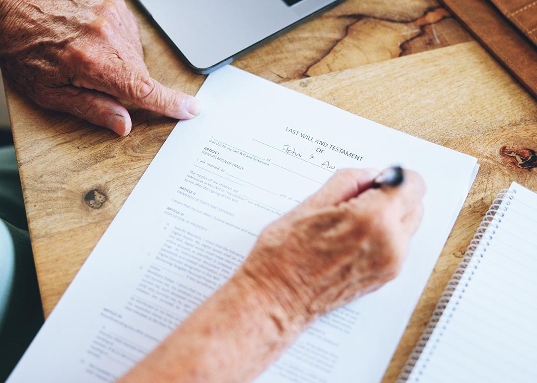 A senior person signing a last will and testament document.