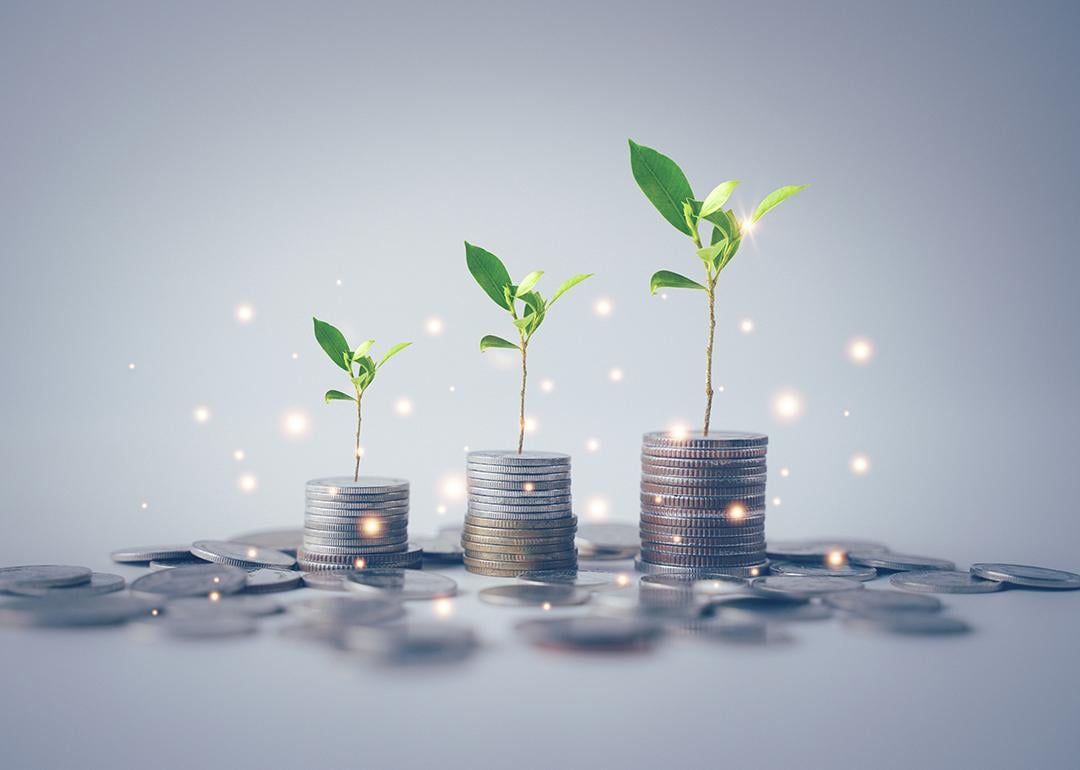 Concept of financial freedom illustrated by stack of coins with growing plants.